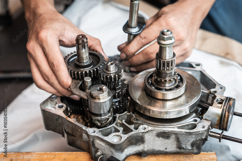 Motorcycle mechanic working on the repair of a motorcycle engine ,working at garage, maintenance, repair motorcycle concept