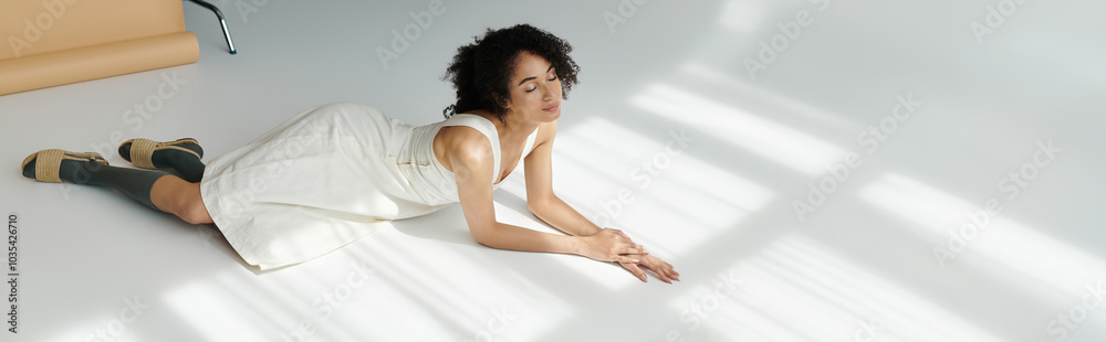 A stylish woman relaxes on the floor, showcasing her elegant outfit in soft sunlight. A stylish woman relaxes on the floor, showcasing her elegant outfit in soft sunlight.