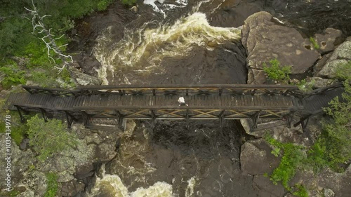 Aerial view of a beautiful bridge over a river surrounded by green forest, Muddus National Park, Sweden. photo