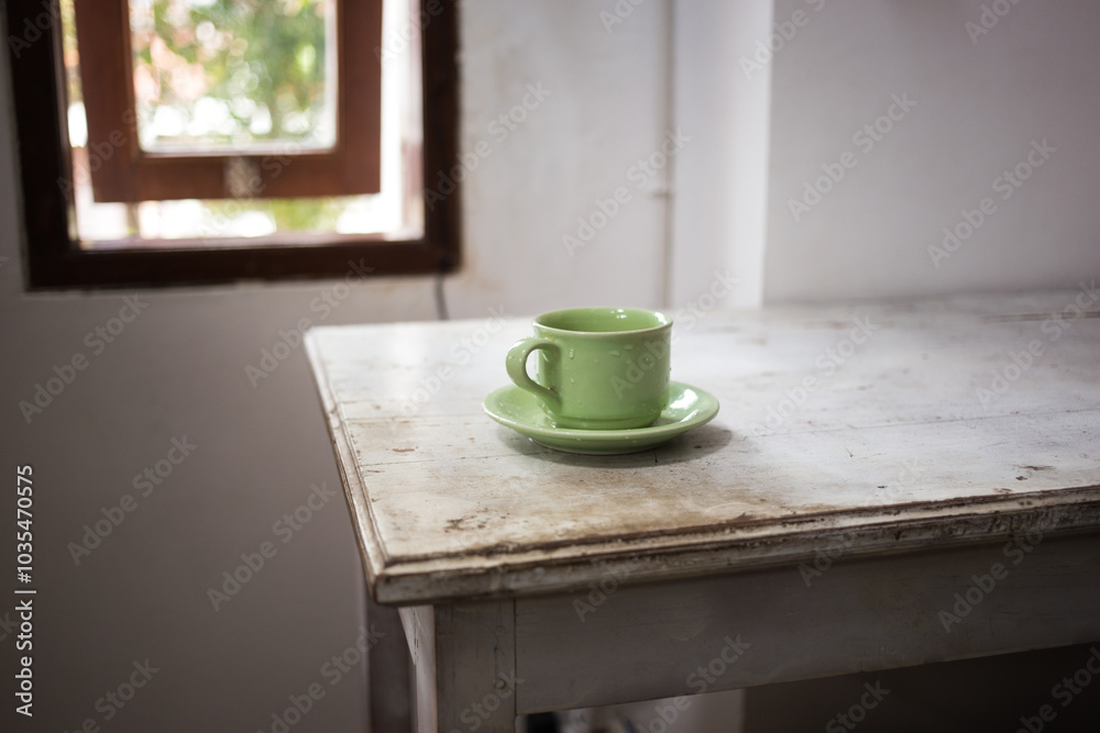 Green cup on white wooden table Green cup on white wooden table