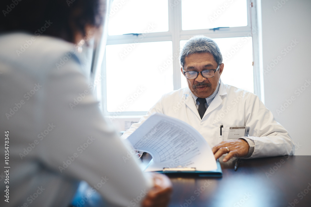 Mature, doctor and clipboard in consultation with patient for medical report, healthcare diagnosis and test results. Medicine, people or paperwork with filing health insurance in clinic for treatment Mature, doctor and clipboard in consultation with patient for medical report, healthcare diagnosis and test results. Medicine, people or paperwork with filing health insurance in clinic for treatment