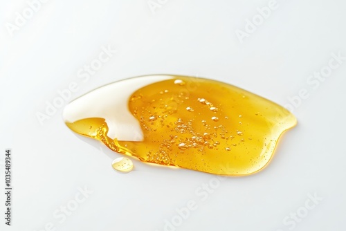 Glossy Puddle of Golden Honey on White Surface