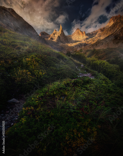 View of Aiguille Dibona peak with dramatic clouds and serene greenery, Saint Christophe en Oisans, France. photo