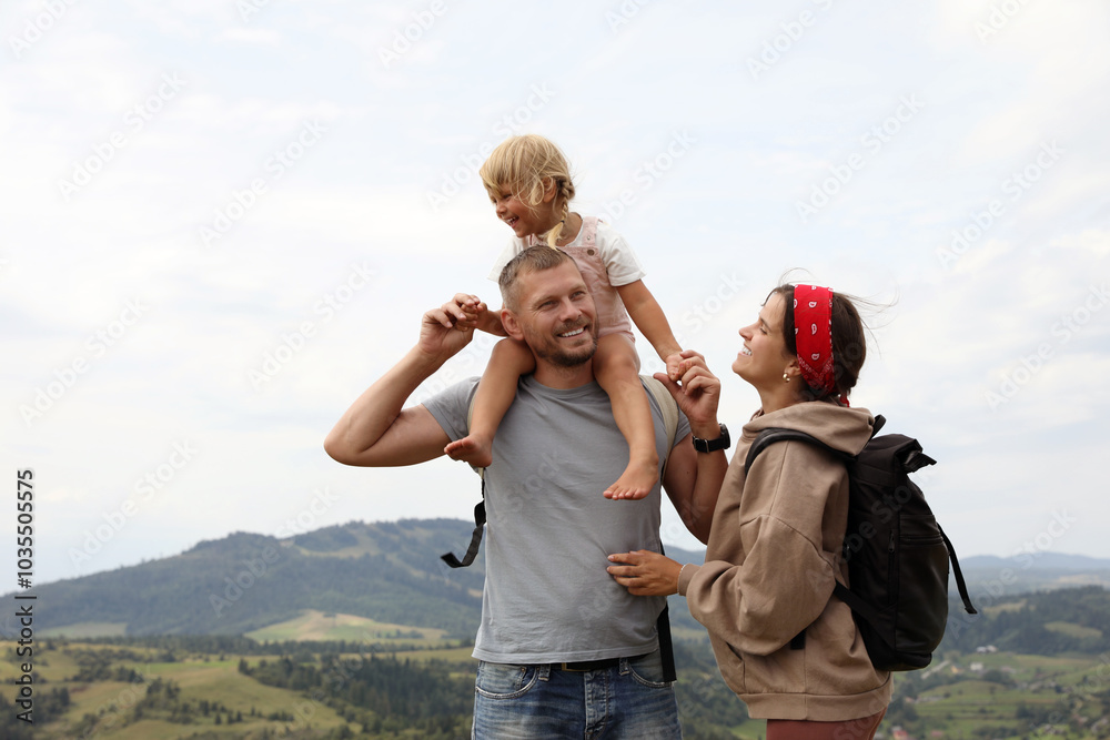Happy family with backpacks travelling in mountains, space for text. Active tourism Happy family with backpacks travelling in mountains, space for text. Active tourism