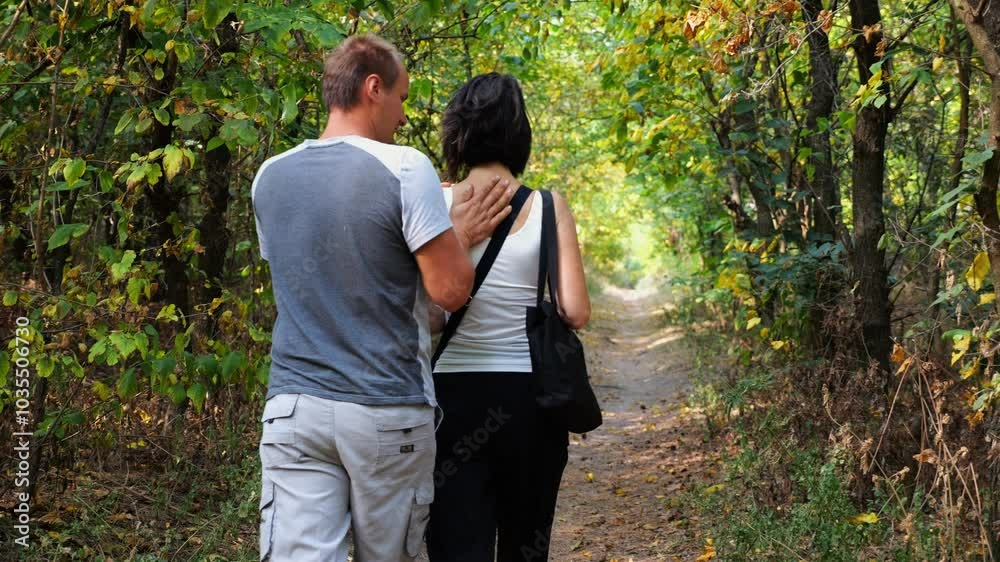 Couple walking along path at summer forest. Happy pair going along trail at wild woodland. Lovers spending time together at nature. Concept of love and happiness. Slow motion Couple walking along path at summer forest. Happy pair going along trail at wild woodland. Lovers spending time together at nature. Concept of love and happiness. Slow motion