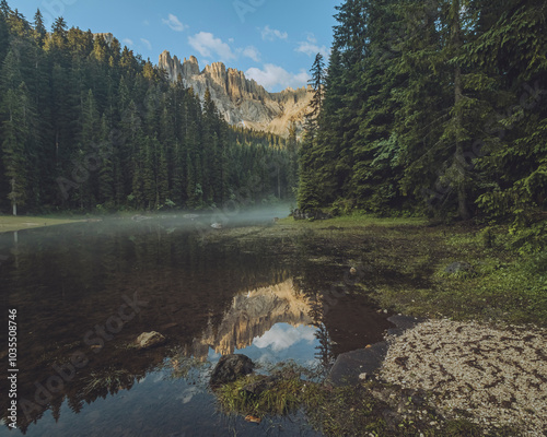 View of Lago di Mezzo surrounded by tranquil forests and majestic mountains, Nova Levante, Italy. photo