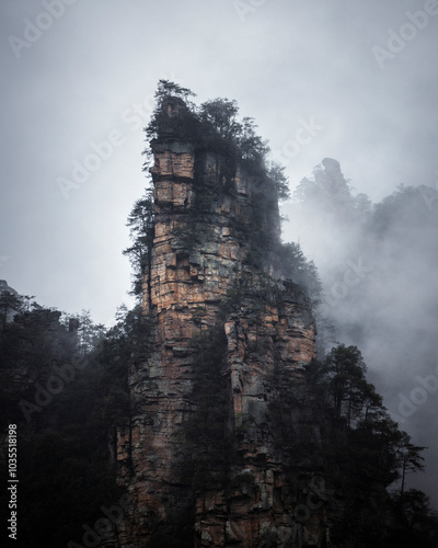 View of majestic rock formations and serene forests shrouded in fog, Zhangjiajie, China. photo