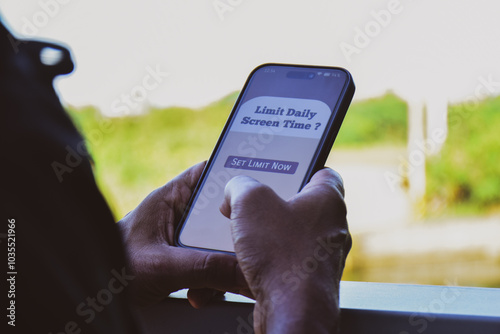A man setting screen time limit on his mobile phone. Selective focus.