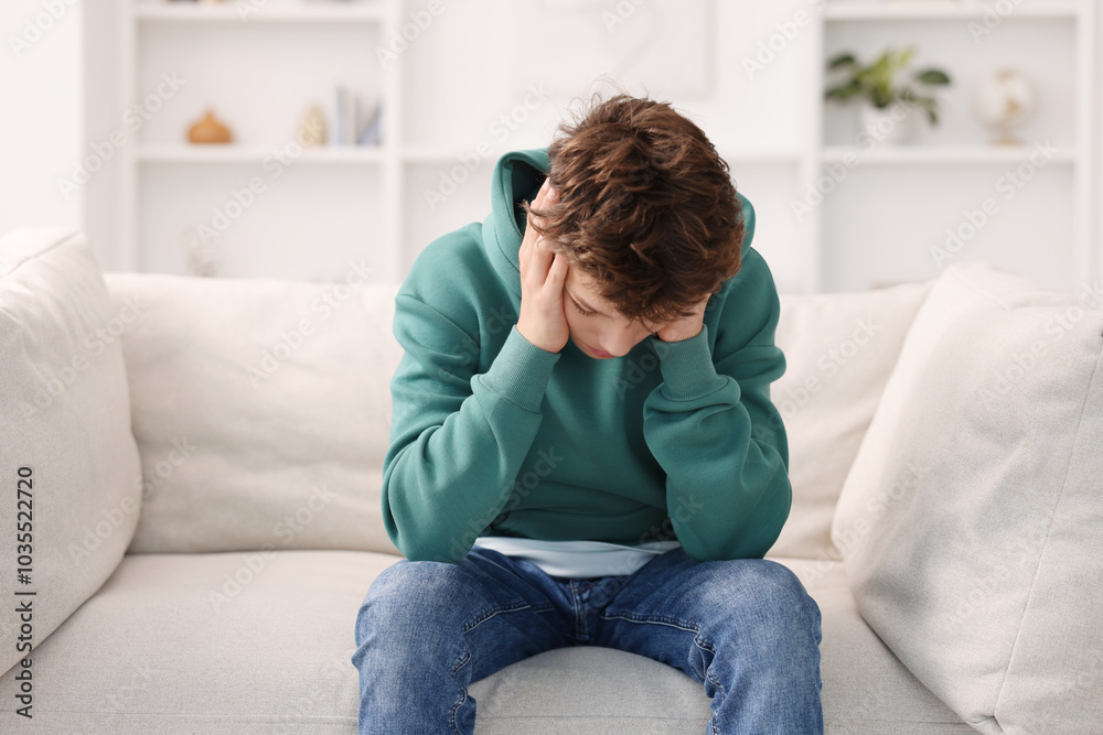 Loneliness concept. Sad teenage boy on sofa at home Loneliness concept. Sad teenage boy on sofa at home