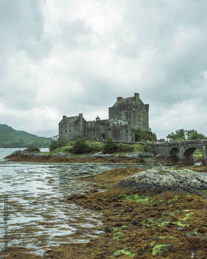 View of misty Eilean Donan Castle by Loch Duich with a picturesque bridge, Dornie, United Kingdom. View of misty Eilean Donan Castle by Loch Duich with a picturesque bridge, Dornie, United Kingdom.