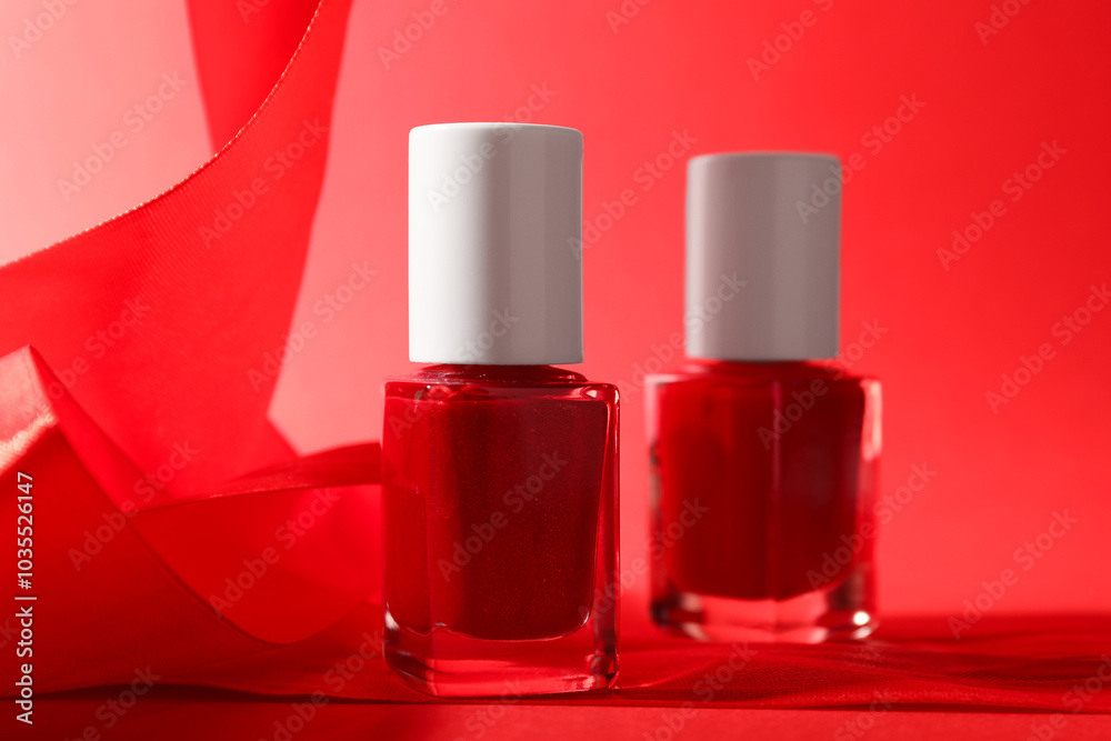 Nail polish in bottles on red background, closeup. Space for text Nail polish in bottles on red background, closeup. Space for text