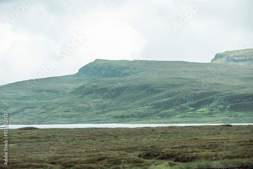 View of serene rolling hills and expansive grassland under a cloudy sky, Portree, United Kingdom. photo