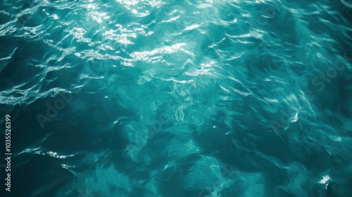 Deep teal water surface, transparent and clear, with soft waves and ripples. Sunlight plays on the water, offering an abstract and serene background for skincare products.