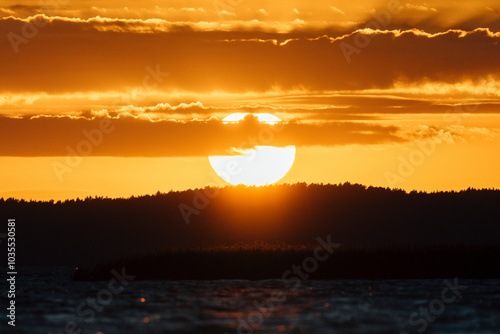 Epic sunset sky with big bright sun going behind the horizon in Lithuania.