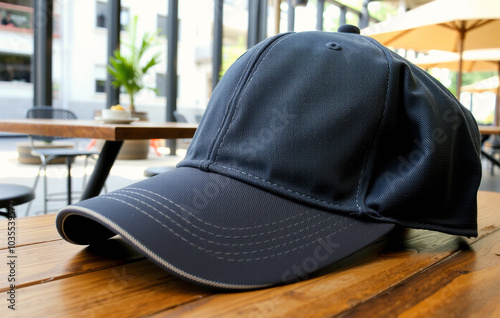 Baseball cap placed on a wooden table for mockup photo