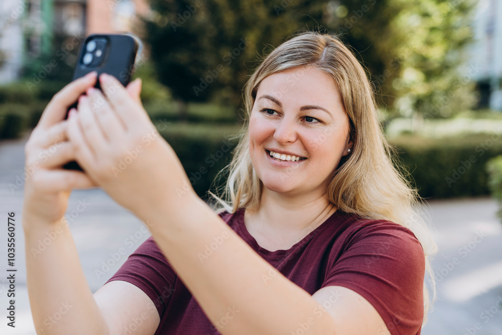 Smiling young woman making selfie using smartphone in the city Smiling young woman making selfie using smartphone in the city