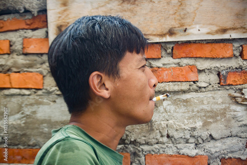 An adult male is smoking a cigarette photo