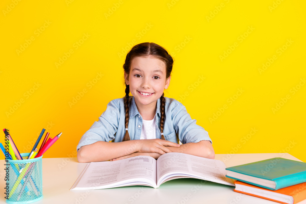 Photo of cute adorable pretty girl wear trendy clothes sit table isolated on yellow color background Photo of cute adorable pretty girl wear trendy clothes sit table isolated on yellow color background