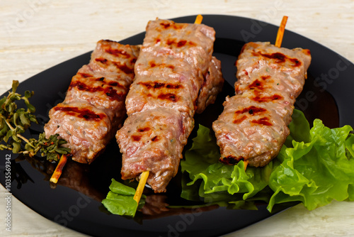 Plate kebabs and lula of a kebab in . food barbecue dinner concept. a plate of skewers of meat and a kebab with herbs. a plate of kebabs, skewers, meat lifestyle and herbs.