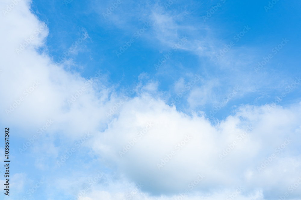 Fluffy white clouds drift across a clear blue sky, painting a breathtaking summer cloudscape Fluffy white clouds drift across a clear blue sky, painting a breathtaking summer cloudscape