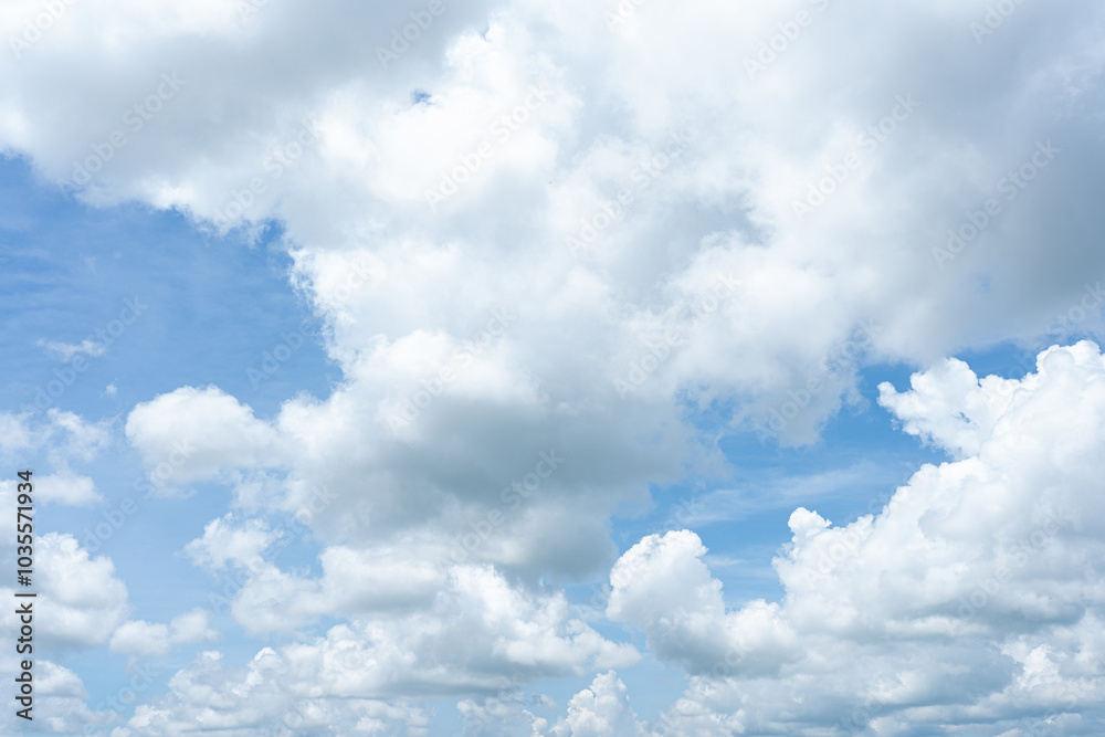 Fluffy white clouds drift across a vibrant blue sky, creating a breathtaking natural spectacle