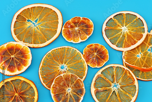 Plate of chips in blue and orange on . party sweet design concept. a bunch of dried oranges lie on a blue . a plate of chips and blue slices lying lifestyle on a white.