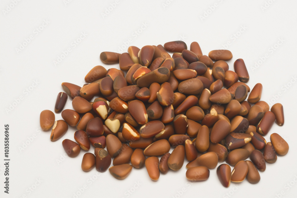 Pine nuts in white on. food seed ingredient concept. handful of peeled nuts on a white . a handful of peeled nuts on a white with lifestyle a green border. Pine nuts in white on. food seed ingredient concept. handful of peeled nuts on a white . a handful of peeled nuts on a white with lifestyle a green border.