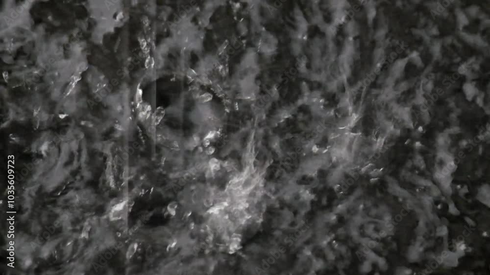 Splashes of rain water on a black background. Rain water drips and creates abstract splashes. Footage 4K, 60 Fps can be used for slow motion Splashes of rain water on a black background. Rain water drips and creates abstract splashes. Footage 4K, 60 Fps can be used for slow motion