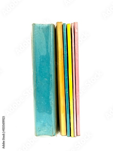 Stack of books with colorful plain cover and various thickness isolated on white background