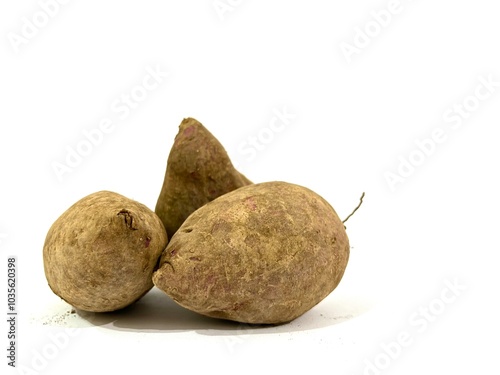 Group of whole organic fresh and raw purple sweet potato with soil and dirt isolated on white background