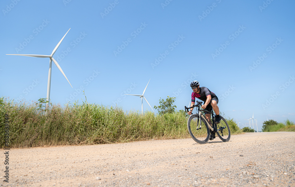 Fototapeta premium Cyclists are riding their bikes for training and touring the wind farms