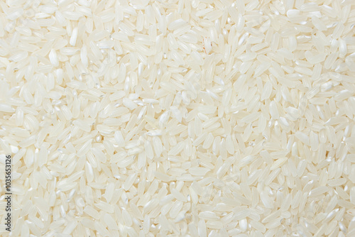 Dry Uncooked White Rice Background - Top View, Flat Lay. Scattered Raw Long Grain Rice. Asian Cuisine and Culture. Healthy Eating Ingredients. Diet Food