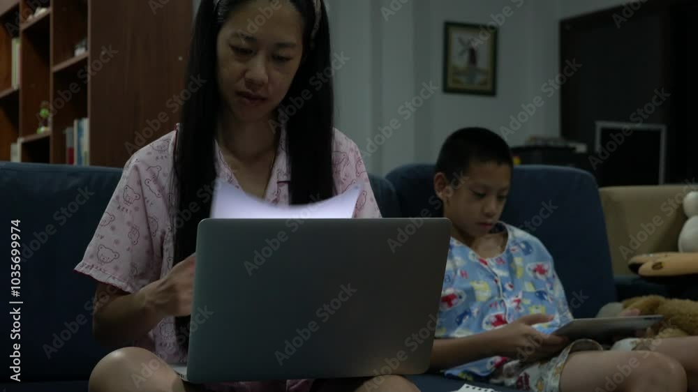 A woman and a boy are sitting on a couch, both using their cell phones. The woman is looking at her phone while the boy is looking at his. The scene is casual and relaxed A woman and a boy are sitting on a couch, both using their cell phones. The woman is looking at her phone while the boy is looking at his. The scene is casual and relaxed