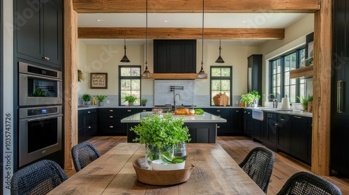 Spacious farmhouse-style kitchen with oak beams, black cabinetry, and a wall-mounted oven. A dining table centerpiece features a small vase of green plants.