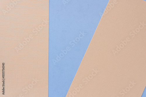 textured beige pink paper sheets on blue with a geometric blank shape between