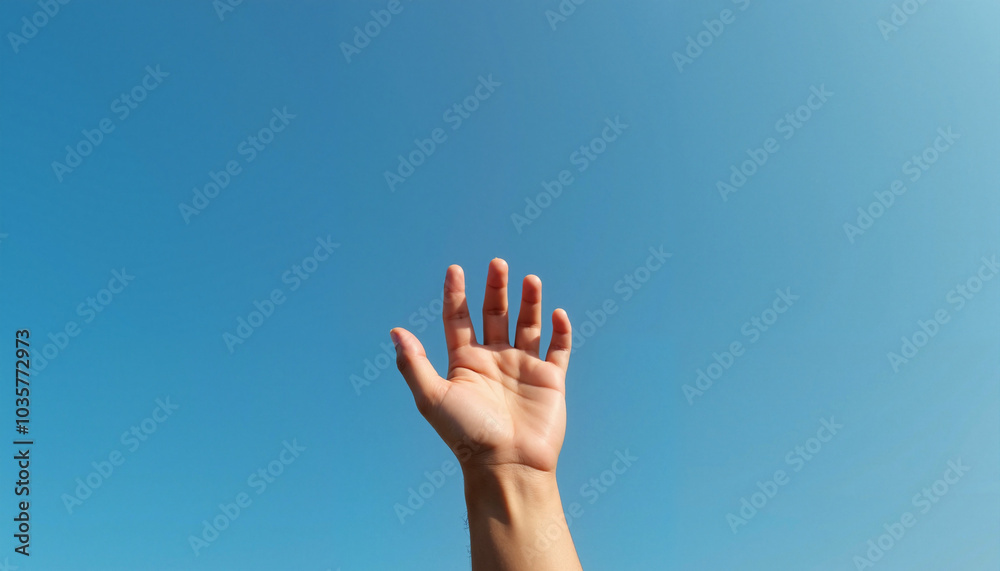Hand reaching towards the blue sky with a feeling of hope and freedom Hand reaching towards the blue sky with a feeling of hope and freedom