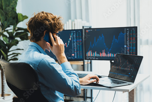 Foto Successful young investor stock trader calling on smartphone to business partner with dynamic financial exchange investment laptop screen in current market graph in real time at modern office