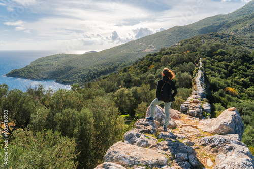 Young sport woman walking on Lycian Way in Turkey close to Kalkan town - sport outfit.