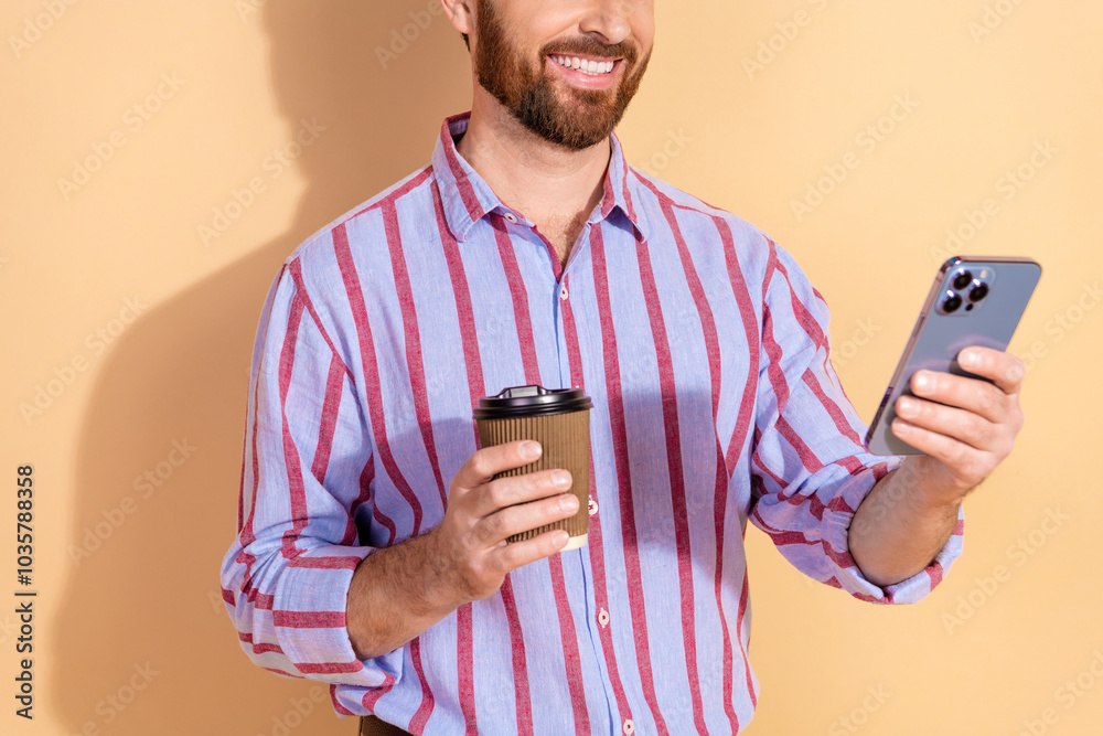 Cropped photo of attractive young man hold device coffee paper cup dressed stylish striped formalwear isolated on beige color background Cropped photo of attractive young man hold device coffee paper cup dressed stylish striped formalwear isolated on beige color background