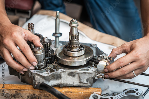 Motorcycle Engine Rebuild,Close up view of Motorcycle mechanic repairing gearbox,working at garage, maintenance and repair motorcycle concept