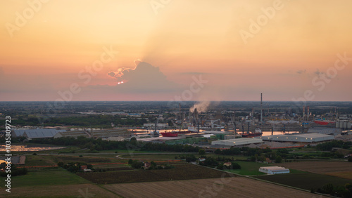 Industrial and port area of Ravenna ,chemical and petrochemical pole,thermoelectric,metallurgical plants and hydrocarbon refinery and liquefied natural gas tanks at sunset photo