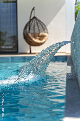 Swimming pool at sunny day with waterfall closeup 