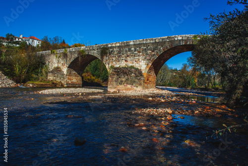 Φωτογραφία a historic stone arch bridge spanning over a shallow river