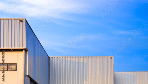 Industrial Factory Building with Geometric Metal Corrugated Steel Exterior Wall and Aluminium Roof against Blue Sky Background, Low Angle view with Copy Space