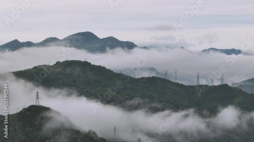 view of a mist over a green mountain with electricity towers, in Qingtian town, Zhejiang, China photo