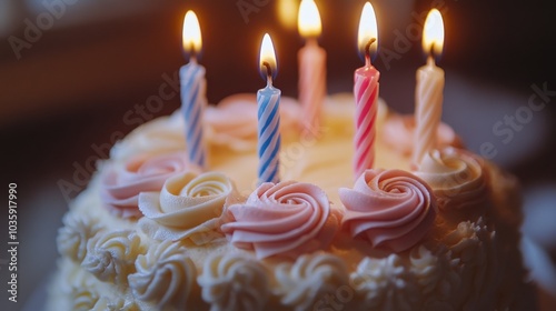 A beautifully decorated birthday cake with lit candles and rose icing details.