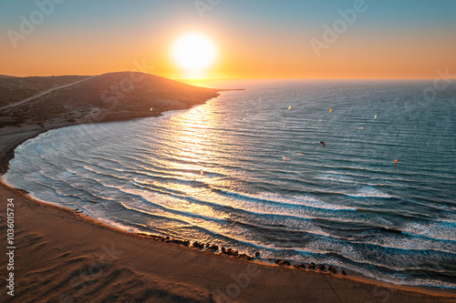 Golden Sunset Over Tranquil Seaside Waves and Distant Hills at a Serene Beach Location