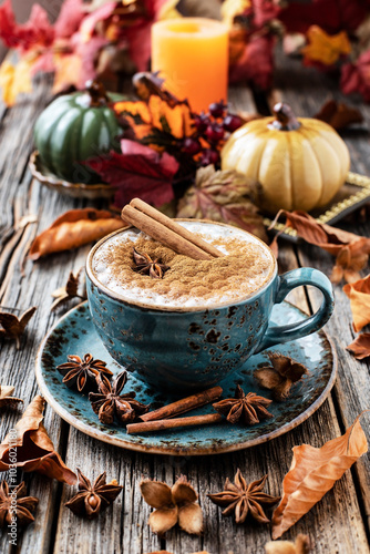 Pumpkin spice latte in mug  on wooden table, selective focus