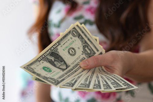 Woman hands giving 1 US dollar banknote