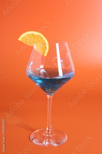 Blue cocktail in glass on orange background